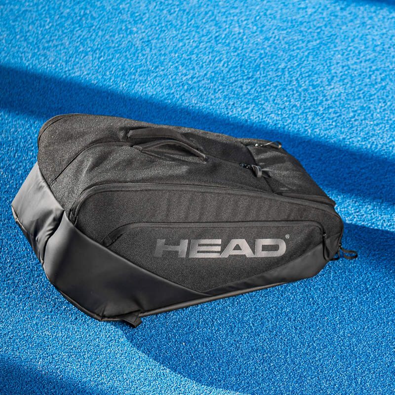Vooraanzicht zwarte HEAD Pro X Padel Bag L Black: ruime, padeltas van gerecycled materiaal op een blauw padel terrein