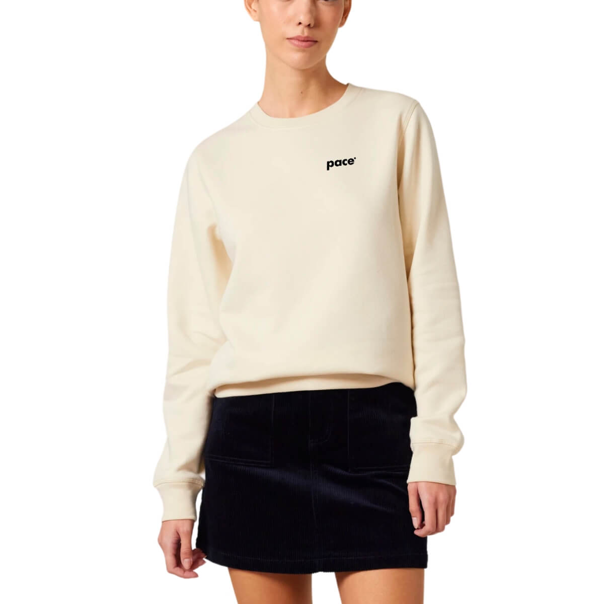 Vrouw met beige sweater met zwart logo pace op de borst