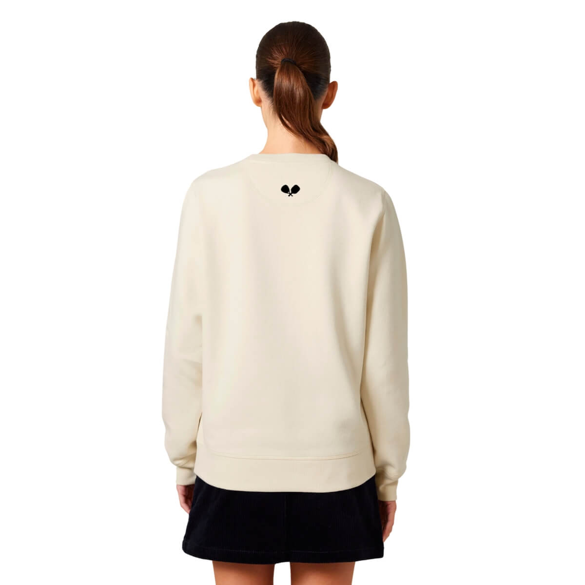 Vrouw met beige sweater met zwart logo pace centraal bovenaan op de achterzijde